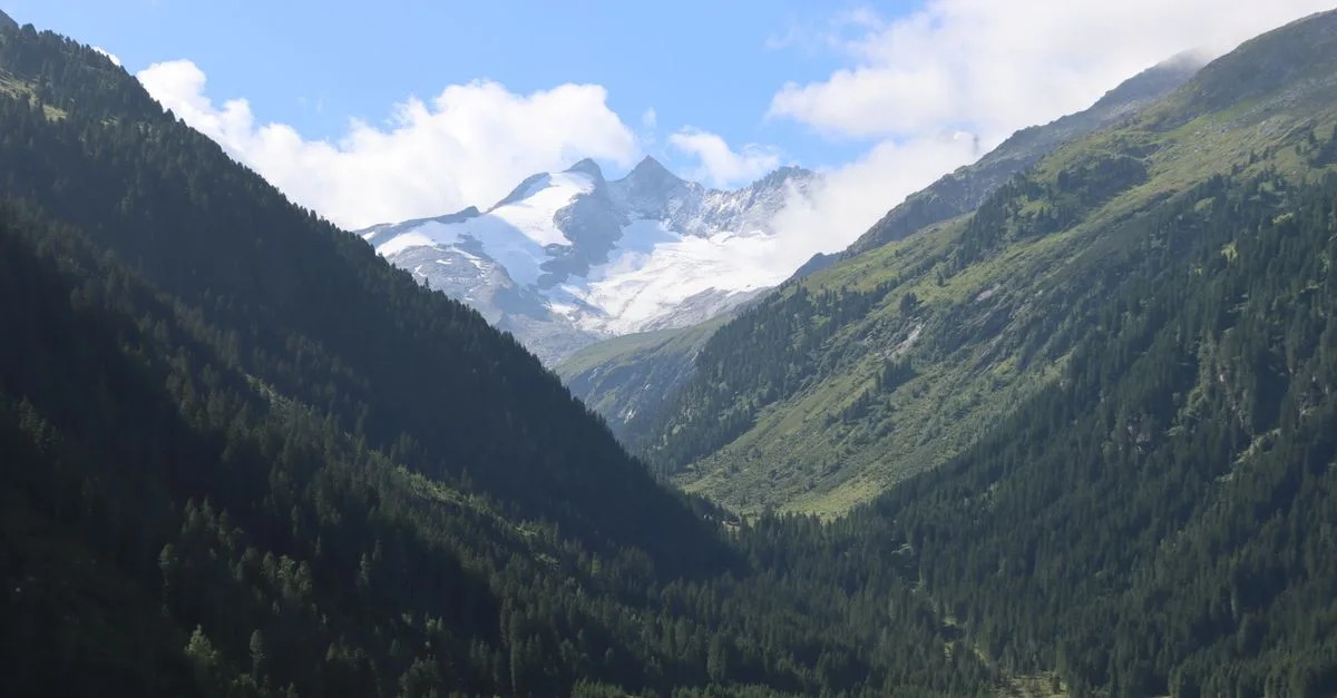 Breathtaking view of snow-capped peaks and lush valleys in the Austrian Alps.