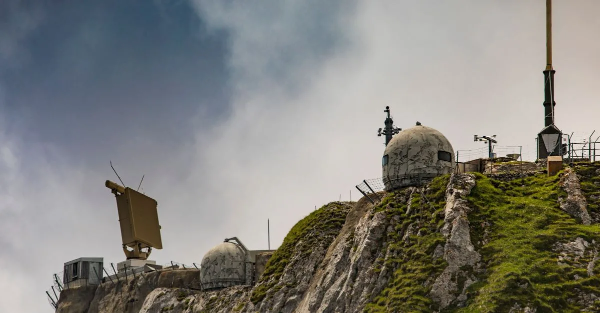 Swiss radar system perched on a rugged mountainside, showcasing technical and natural contrast.