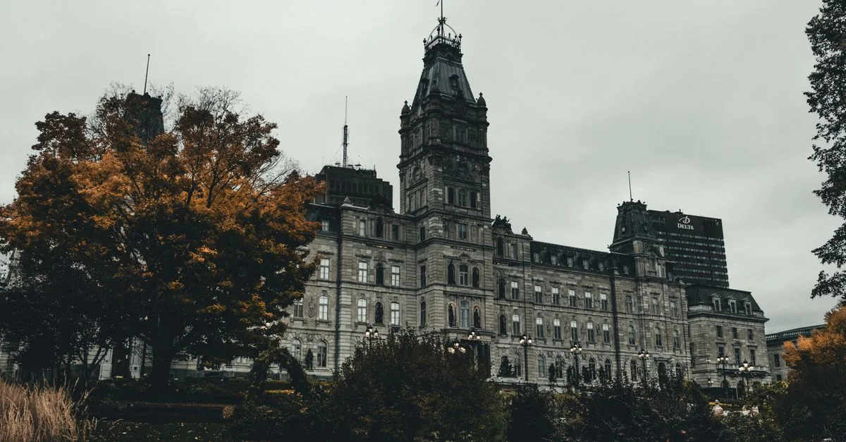 A stunning view of the Quebec City Parliament Building surrounded by autumn foliage.