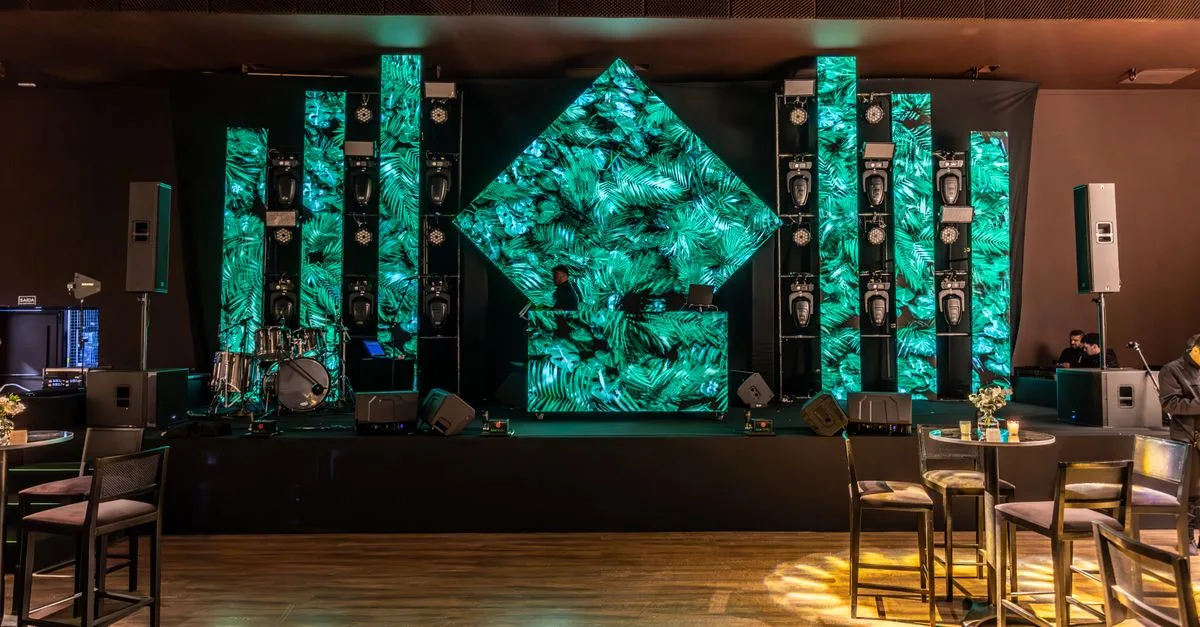 Stunning DJ booth setup with green LED panels in a modern indoor venue.