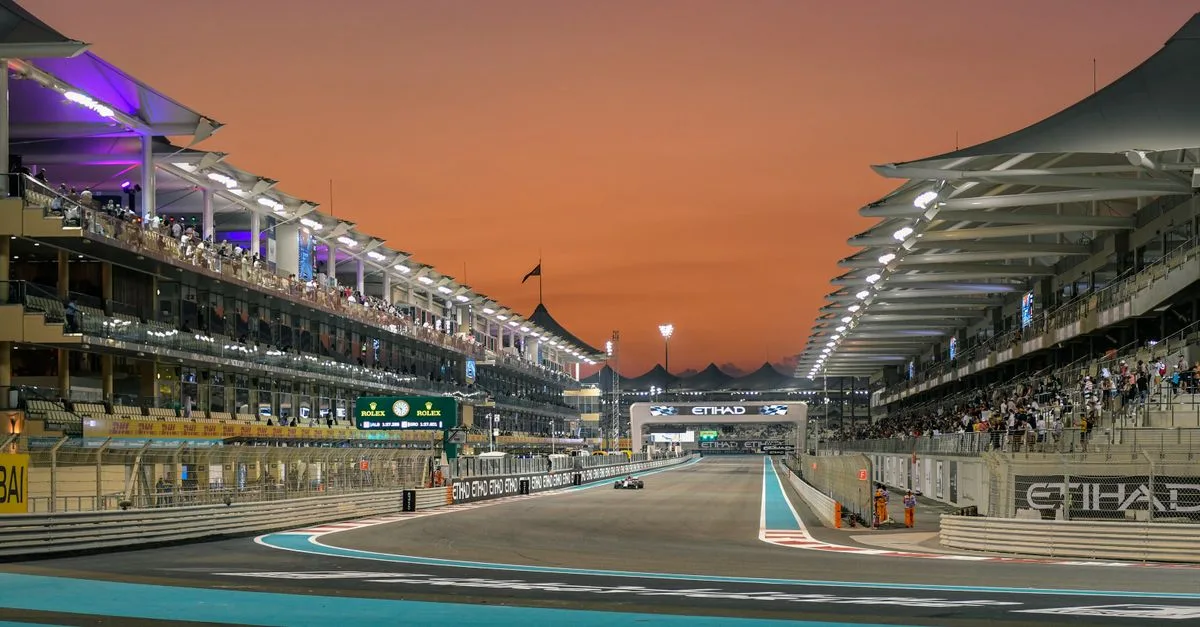 Formula 1 race event at Yas Marina Circuit, Abu Dhabi during sunset.