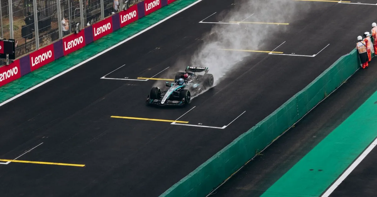 Formula 1 car speeding on wet track during race. High-energy motorsport action.