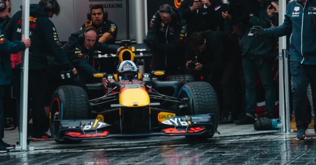 Exciting Formula One car during a dynamic pit stop, showcasing teamwork and precision.