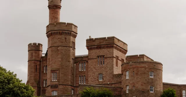 A view of the historic Inverness Castle in Scotland under overcast skies.