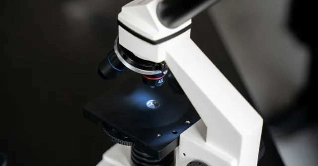 Close-up view of a laboratory microscope with selective focus, ideal for scientific use.