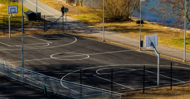 Sunny day at an outdoor basketball court by a lake in Jönköping, Sweden.