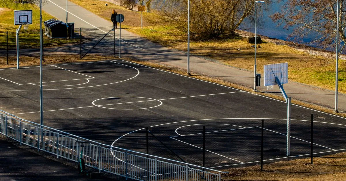Sunny day at an outdoor basketball court by a lake in Jönköping, Sweden.