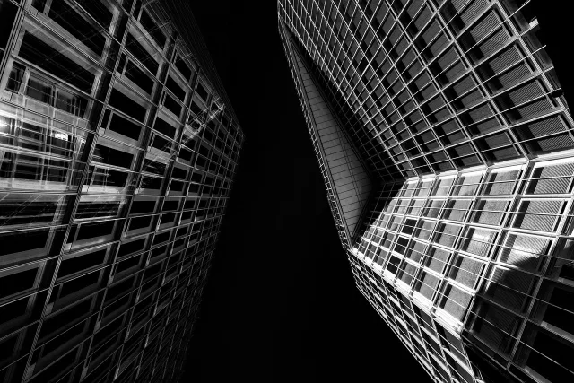 A modern glass office building exterior representing global finance and corporate expansion.