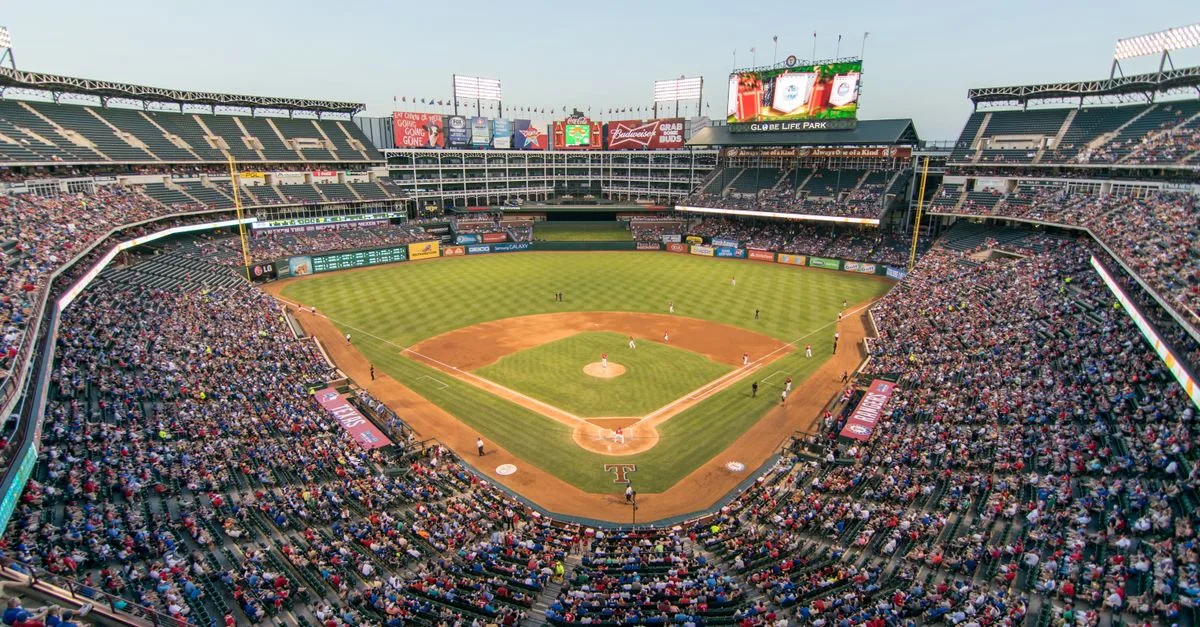 Aerial view of a lively baseball game at the iconic Globe Life Park filled with cheering fans.