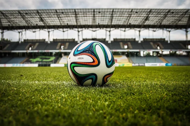 A wide view of a professional football stadium at night under bright floodlights.