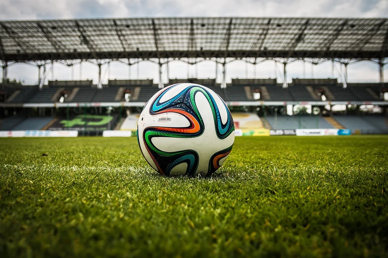 A wide view of a professional football stadium at night under bright floodlights.