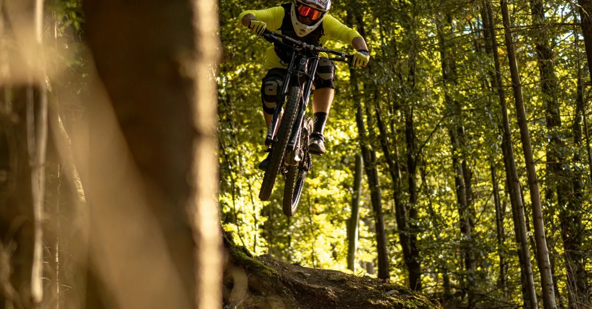 Dynamic shot of a mountain biker jumping on a forest trail in Heidenheim an der Brenz, Germany.
