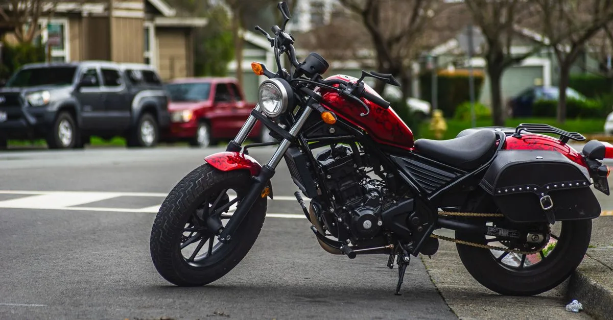 A striking red motorcycle parked on an urban street corner showcasing urban lifestyle.