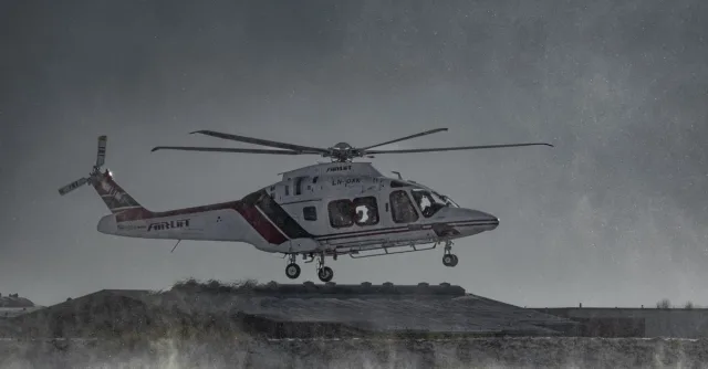 Air ambulance helicopter flying over a snowy terrain in winter conditions.
