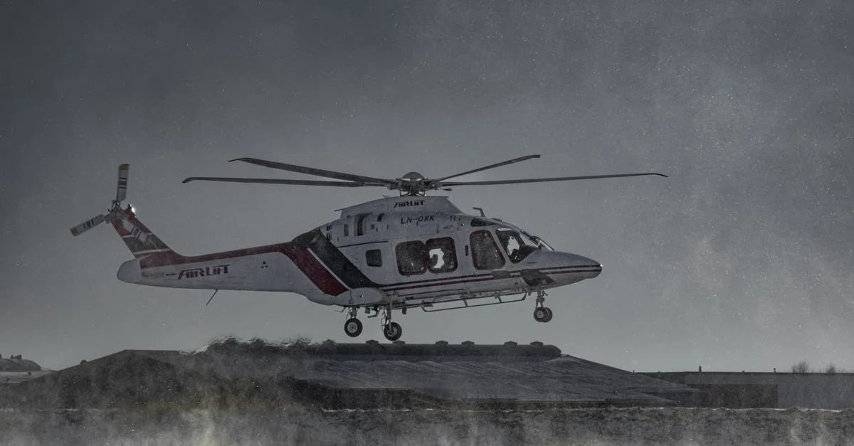 Air ambulance helicopter flying over a snowy terrain in winter conditions.