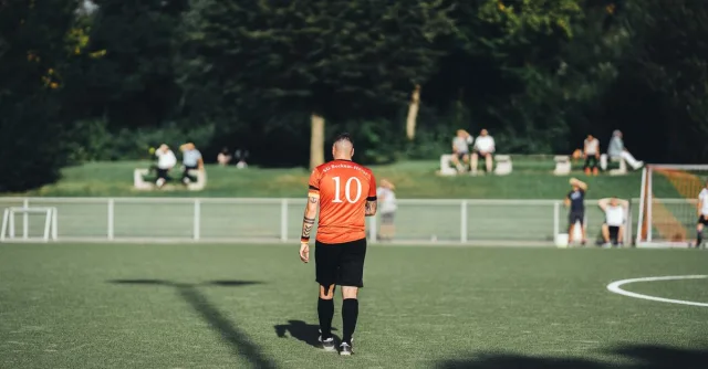 Back view of a football player wearing number 10 on a sunny day.