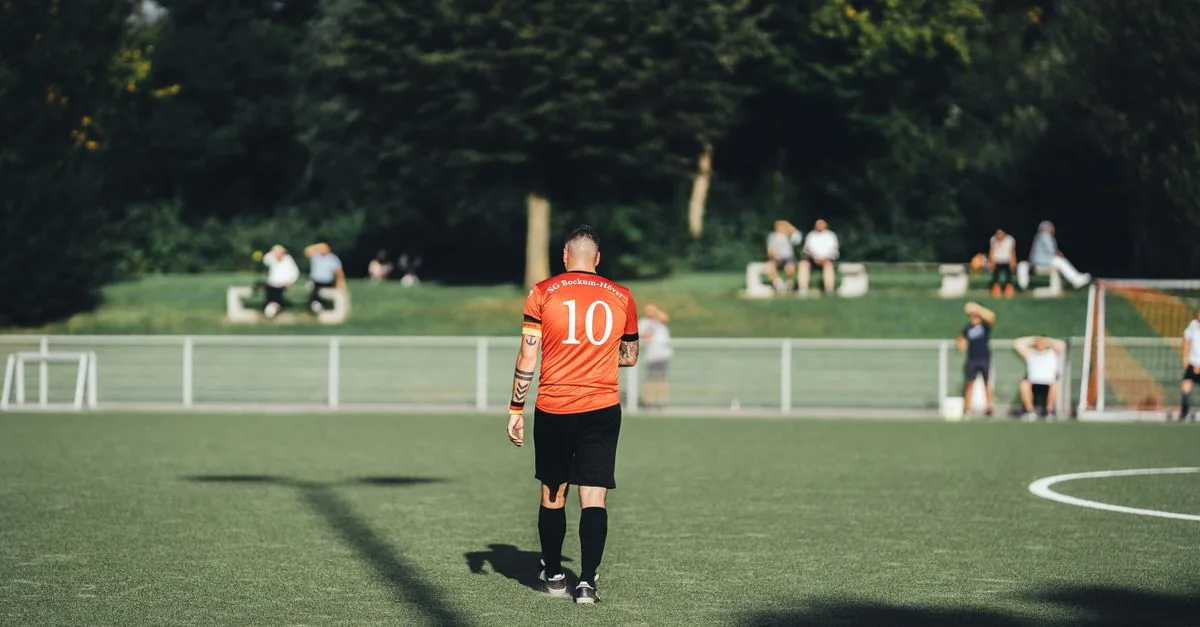 Back view of a football player wearing number 10 on a sunny day.
