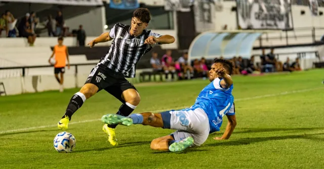 A dynamic moment of soccer players tackling under stadium lights during an exciting match.
