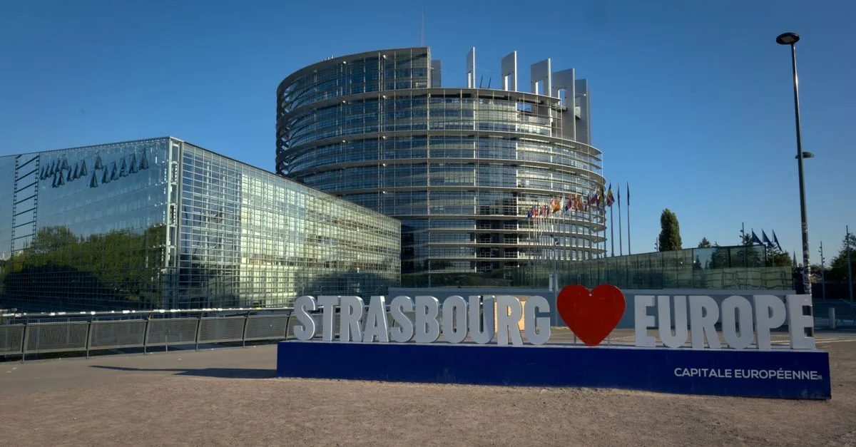 European Parliament building in Strasbourg with a famous sign in front.