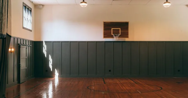 Interior of empty light spacious basketball court with wooden floor in modern sports complex
