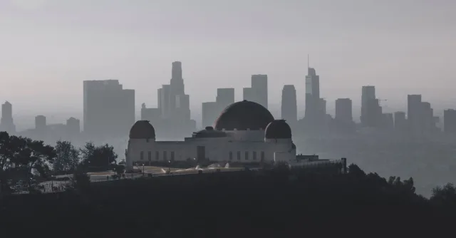 Griffith Observatory with Los Angeles skyline in the background during a hazy day.