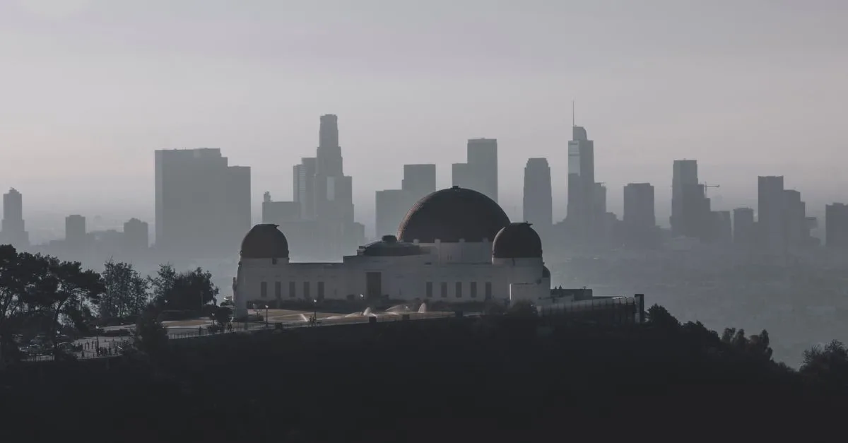Griffith Observatory with Los Angeles skyline in the background during a hazy day.
