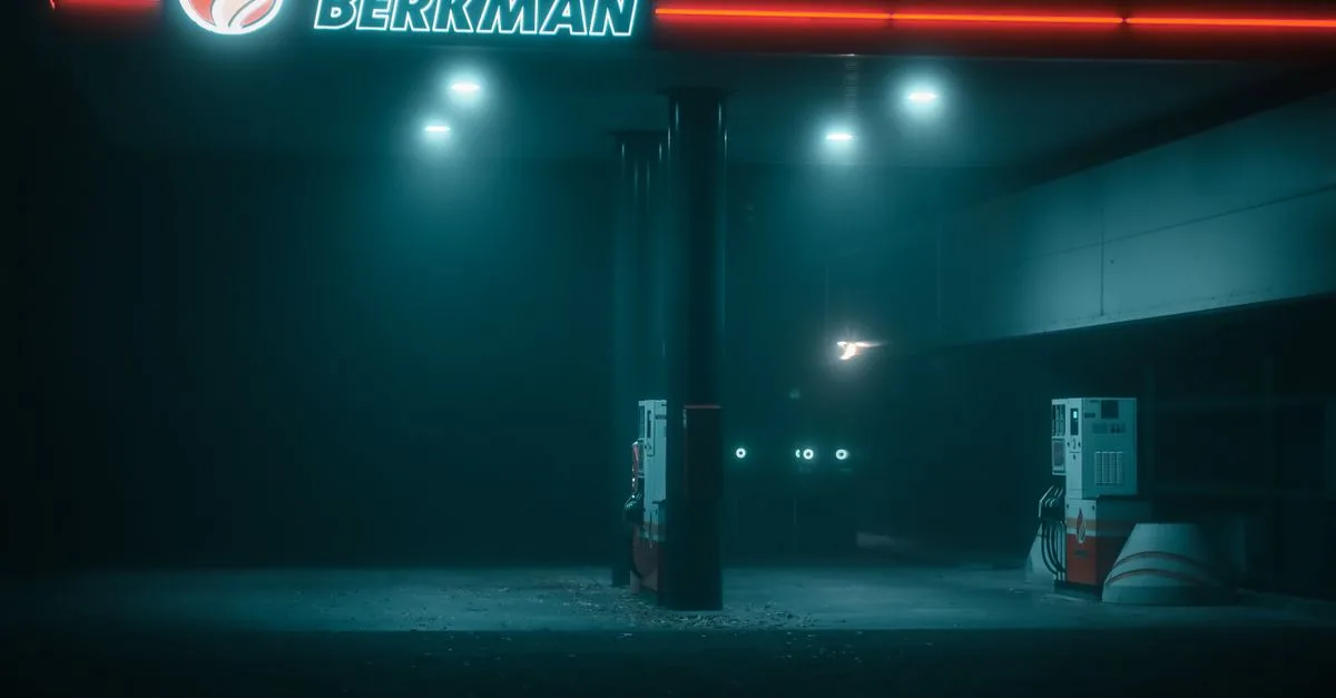 Eerie gas station at night with BERKMAN signage illuminated in fog.