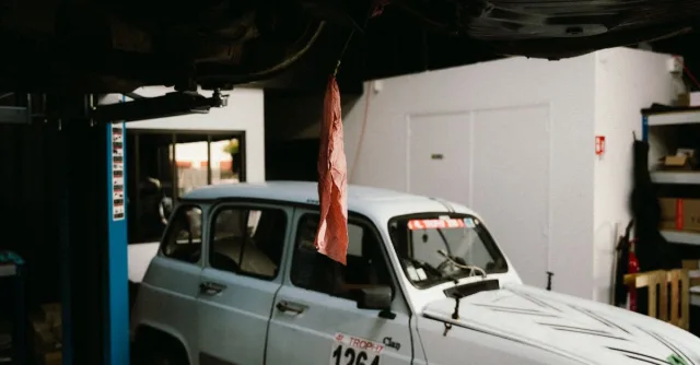 A vintage car in a garage workshop in Montigny-le-Bretonneux, France, showcasing automotive history.