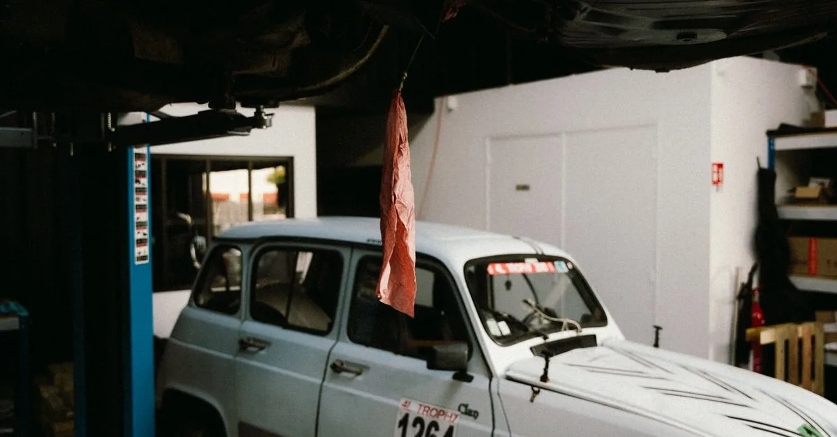 A vintage car in a garage workshop in Montigny-le-Bretonneux, France, showcasing automotive history.