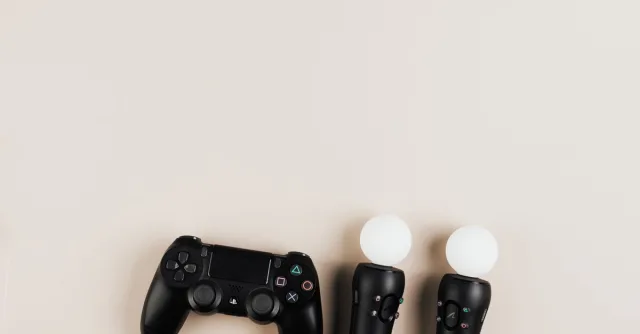 Black gaming controllers arranged on a light background with ample copy space.