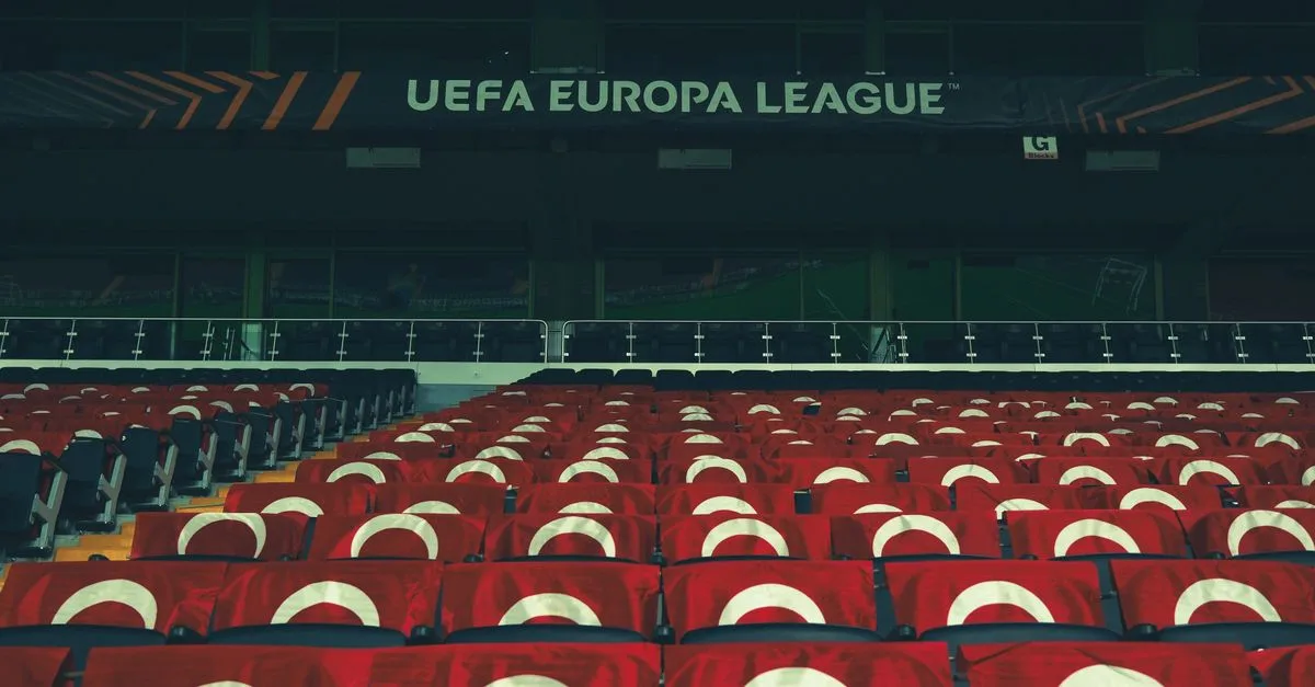 Rows of empty stadium seats adorned with UEFA Europa League banners, creating a sporting event atmosphere.