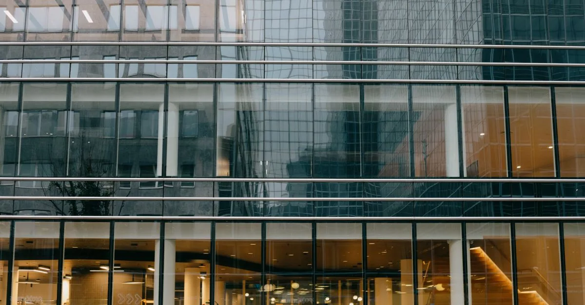 Contemporary glass facade of an office building in Brussels reflecting urban architecture.