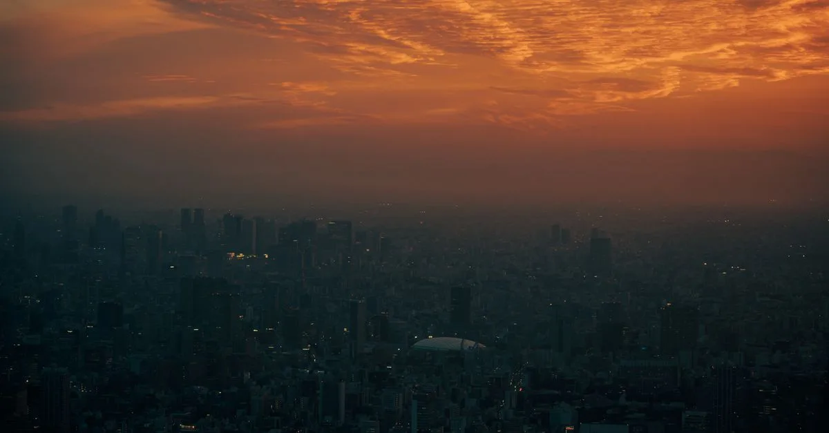 A stunning sunset over Tokyo's skyline, casting an orange hue across the cityscape.