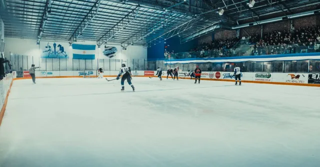Dynamic ice hockey game at a packed indoor arena in Buenos Aires, showcasing intense action on the rink.