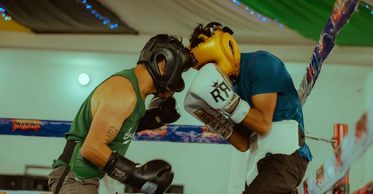 Two boxers engaged in a thrilling match wearing protective headgear and gloves.