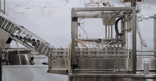 Automated beverage can packaging in a modern factory setting.