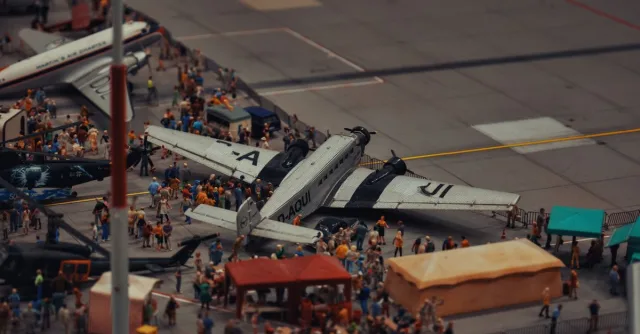 A detailed miniature scene of airplanes and people at a crowded airport display.