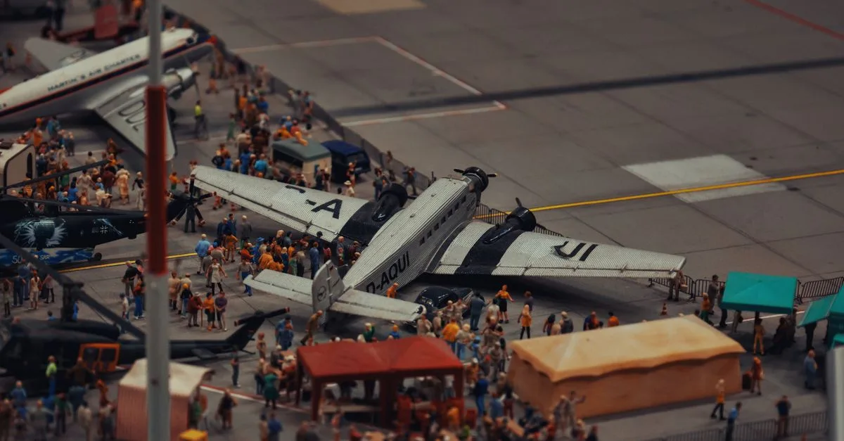 A detailed miniature scene of airplanes and people at a crowded airport display.
