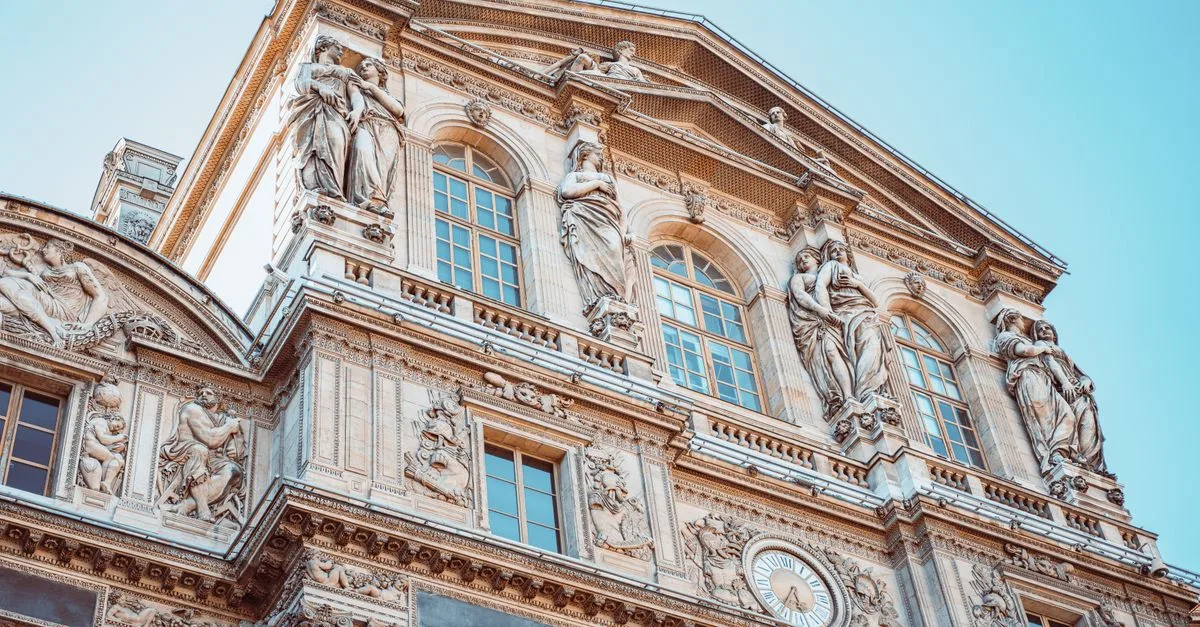 Detailed view of the historic Louvre Museum facade in Paris capturing intricate sculptures and architecture.