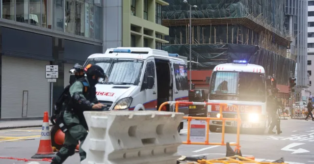 Military police truck equipped with emergency lights moving on fenced road in city during protests in centre