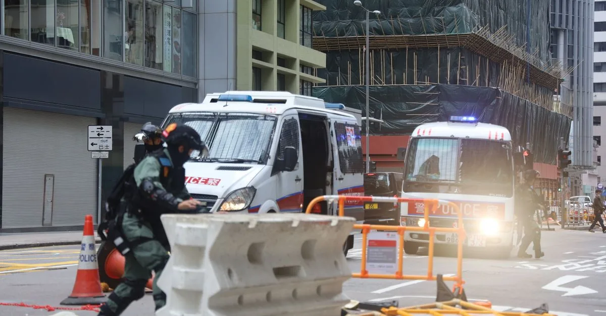 Military police truck equipped with emergency lights moving on fenced road in city during protests in centre