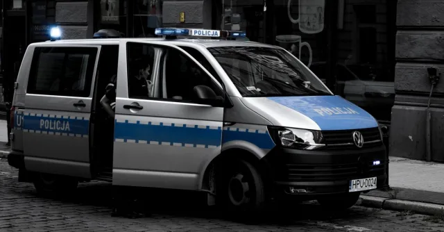 A police van parked on a cobblestone street in an urban setting.