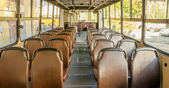 Interior view of an empty vintage bus in Wrocław, Poland, showcasing rows of brown seats.