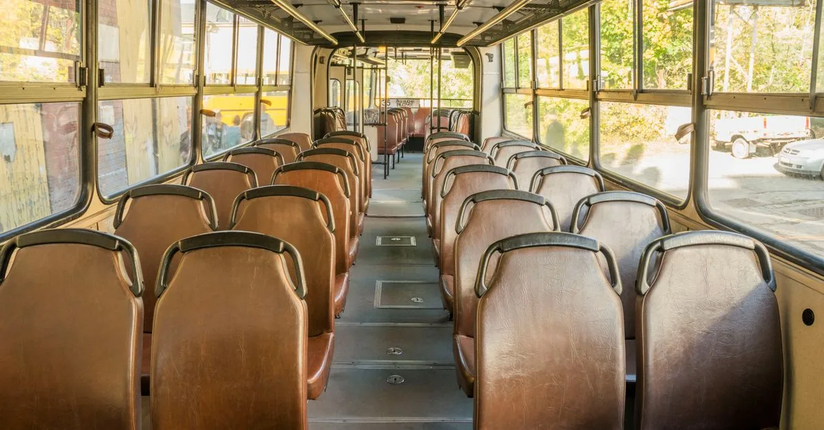 Interior view of an empty vintage bus in Wrocław, Poland, showcasing rows of brown seats.