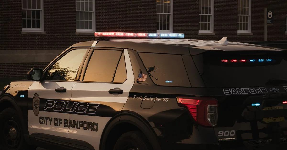Sanford police vehicle parked outdoors at twilight, showcasing red and blue lights.