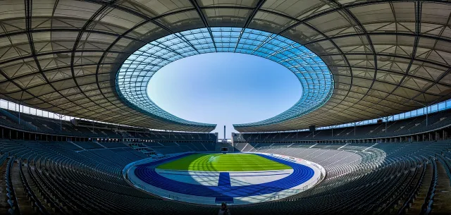 A professional football stadium lit up at night during a match.