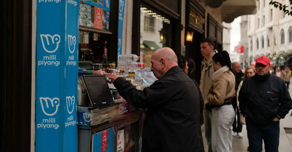 People buying lottery tickets and beverages from a street vendor on a bustling urban street.