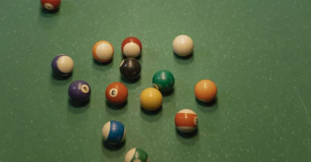 A top view of scattered colorful billiard balls on a pool table, ideal for gaming themes.