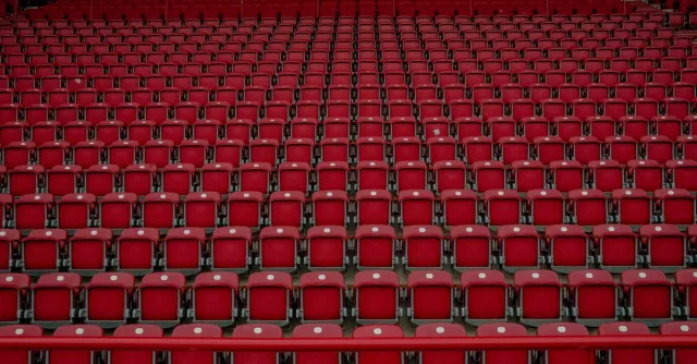 Rows of empty red seats in a Berlin stadium, creating a symmetrical pattern.