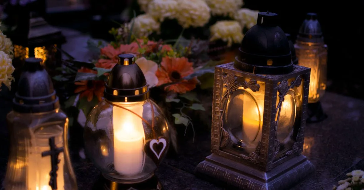 Lanterns with candles illuminate a cemetery on All Saints' Day.